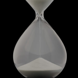 Photo of sand pouring in an hourglass